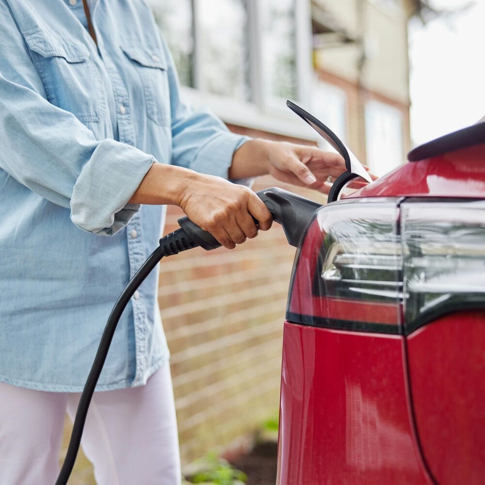 woman plugging in tesla charger